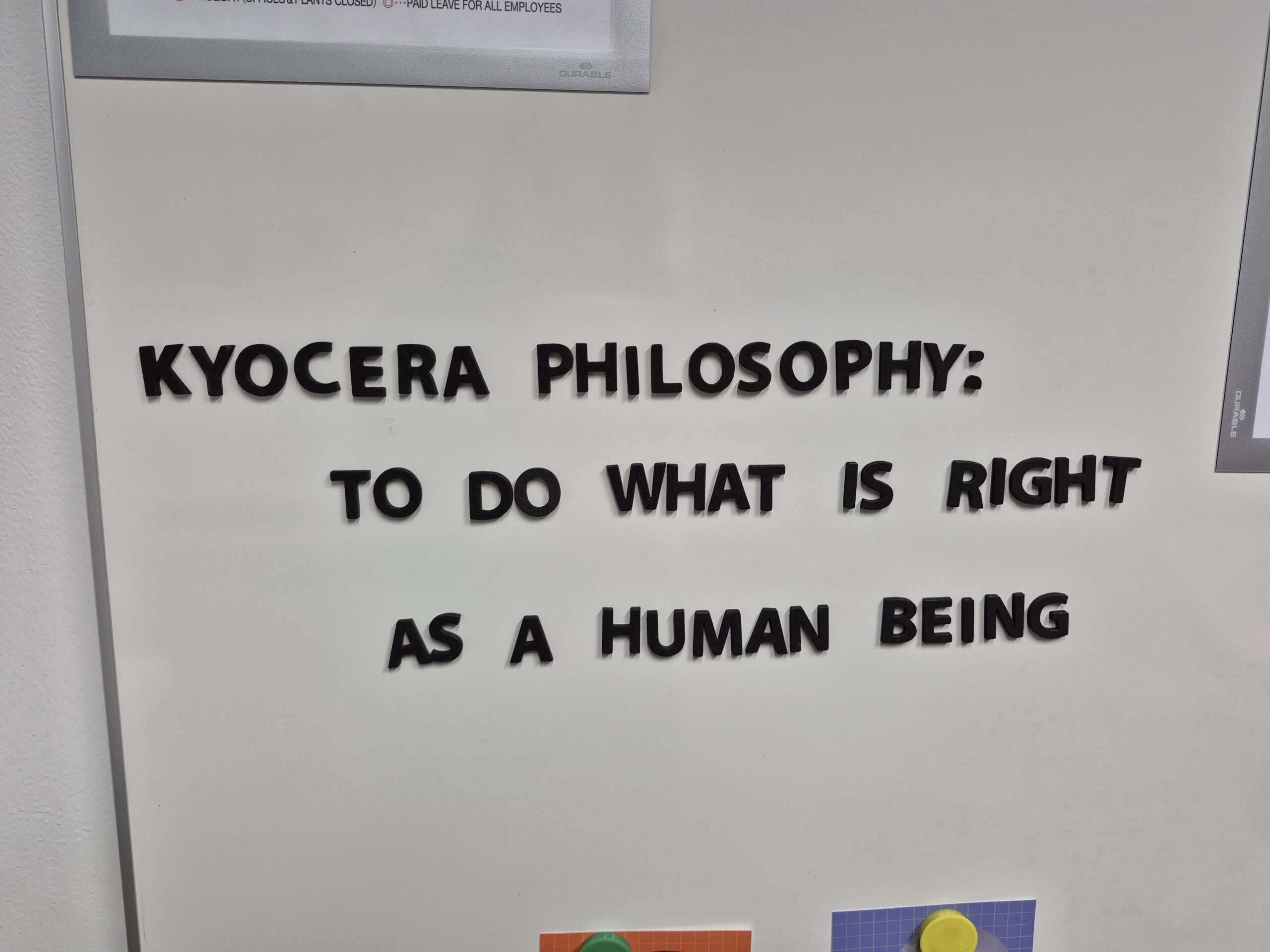Schwarzer Text auf einer weißen Wand lautet: KYOCERA PHILOSOPHY- TO DO WHAT IS RIGHT AS A HUMAN BEING